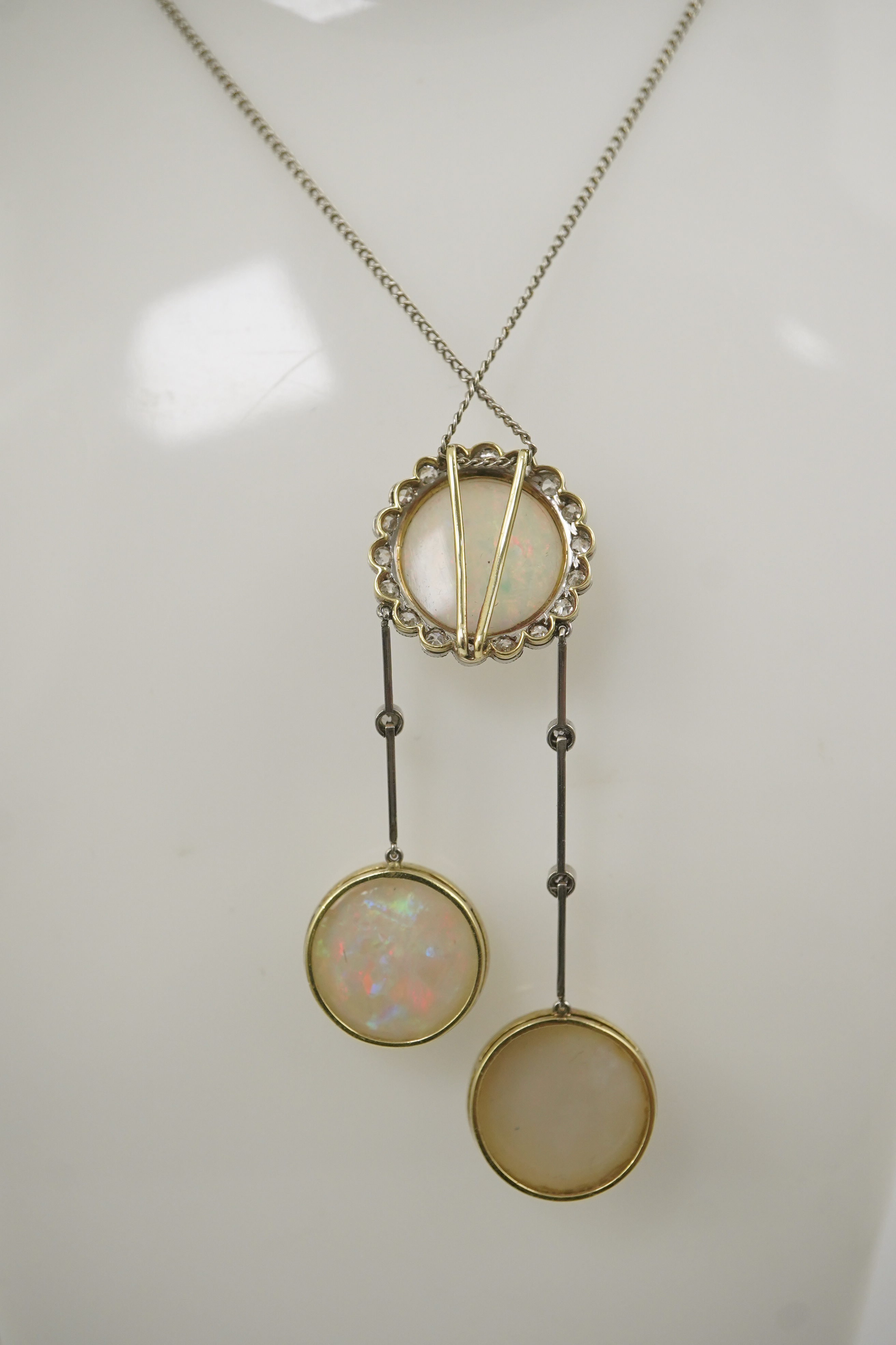 A Belle Epoque platinum and gold, white opal and millegrain set diamond double drop pendant necklace, the chain by Child and Child